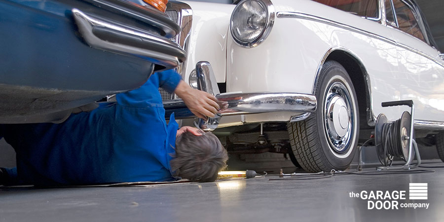 Men Repairing His Car - Garage Door